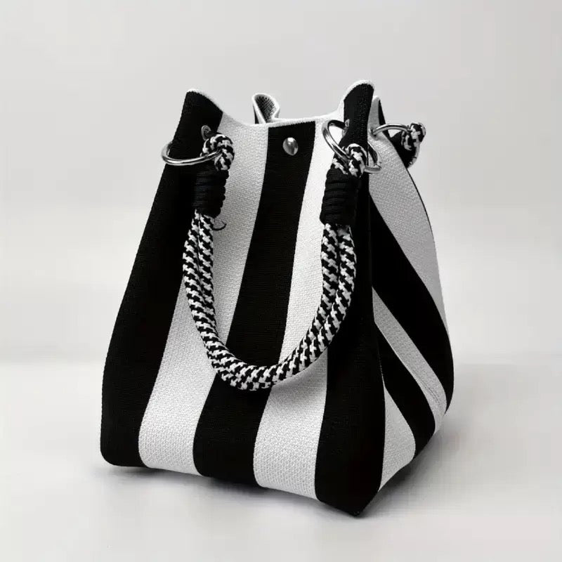 Black and white striped woven bucket bag with patterned rope handle