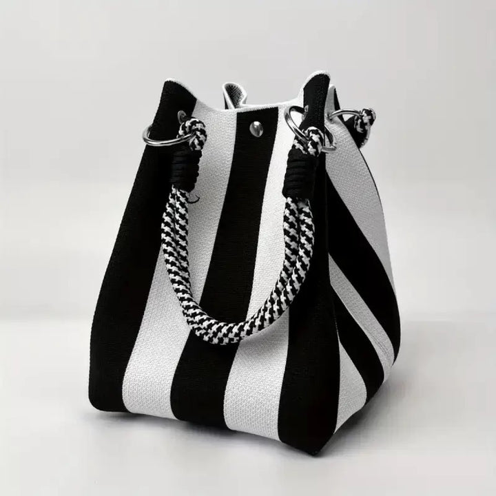 Black and white striped woven bucket bag with patterned rope handle